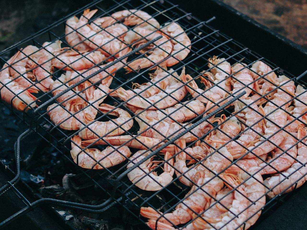 Tasty shrimp grilling on a barbecue grill outdoors, perfect for summer cookouts.